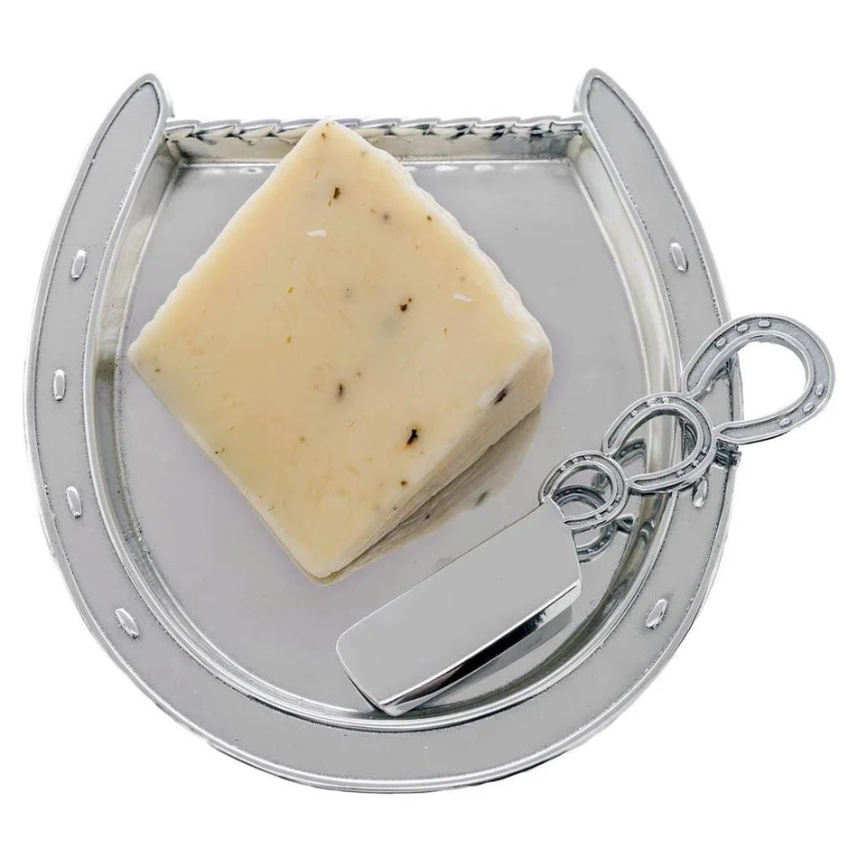 Block of cheese on a metal cheese board with a knife on a white background