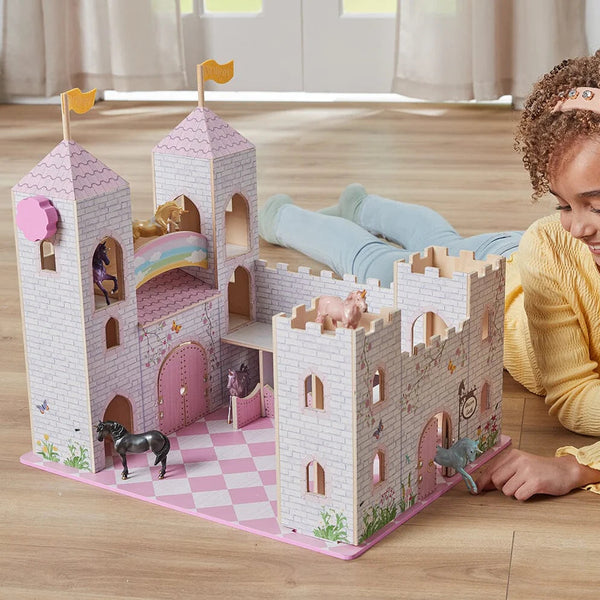 Child playing with a toy castle on a wooden floor